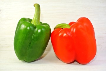 green and red bell pepper on a white wooden background