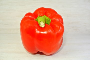 green and red bell pepper on a white wooden background