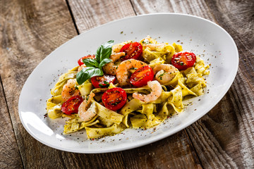 Shrimps with pasta tagliatelle with spinach and tomatoes