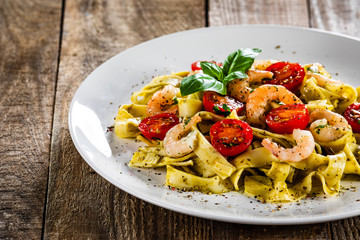 Shrimps with pasta tagliatelle with spinach and tomatoes
