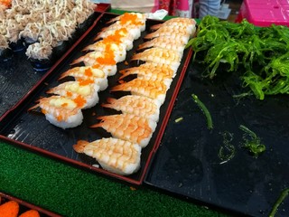 Black orange and red caviar sushi, placed on a black tray