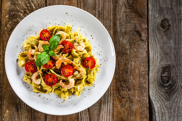 Shrimps with pasta tagliatelle with spinach and tomatoes