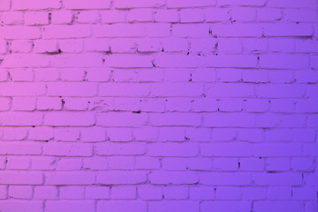 Fototapeta na wymiar Brick wall in neon light. Modern colors purple and pink background