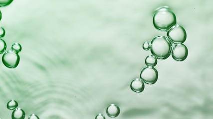 transparent gas bubbles on water surface. Worms-eye low angle with crystal bubbles in purified water on green background. cosmetic backdrop with copy space