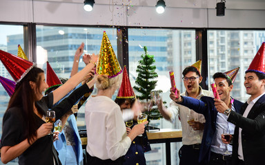 Business men and women with glasses of champagne celebrating Christmas and New Year for success in Business at the Office