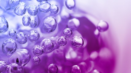transparent gas bubbles on water surface. Worms-eye low angle with crystal bubbles in purified water on pink, purple, violet background. cosmetic backdrop with copy space