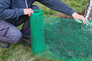 A man holds a plastic net that is useful in gardening.