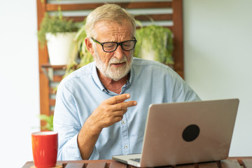 Fototapeta premium Portrait senior man using laptop for working at home, Freelance concept - Image