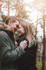 Fototapeta premium Happy young couple in love friends dressed in casual style walking together on nature park forest in cold season, family advenure travel