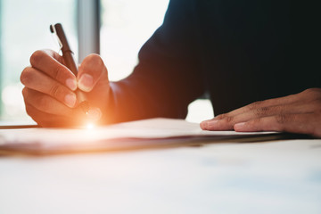 Business man signing a document to agree on financial planning after complete agreement plan in meeting room, investment concept, success concept