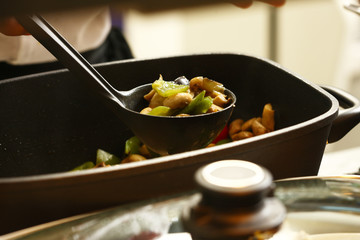 professional cook in kitchen preparing food for customers showing hands and utilities