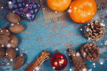 Obraz na płótnie Canvas Christmas decoration frame with gifts, pine cones, tangerine, cinnamon sticks