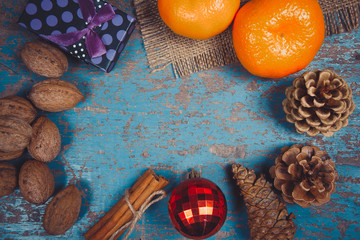 Christmas decoration frame with gifts, pine cones, tangerine, cinnamon sticks