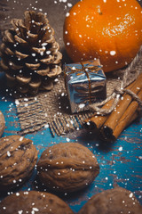 Christmas decoration with gifts, pine cones, tangerine, cinnamon sticks and walnuts