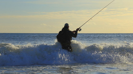 Surf fishing on the Jurassic Coast near Seaton in Devon