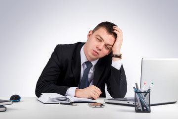 Office, finances, internet, business, success and stress concept-Frustrated young businessman working on laptop computer at office