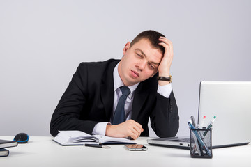 Office, finances, internet, business, success and stress concept-Frustrated young businessman working on laptop computer at office