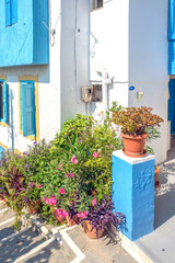 Fototapeta na wymiar Alley with steps and flower pots in the center of Kokkari in Samos, Greece.