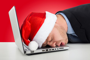 businessman with santa hat sleeping on desk office after christmas party and happy new year