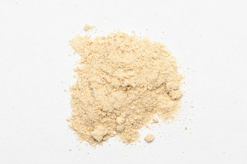 Ground ginger pile top view, powder heap, crushed dried root flour close up
