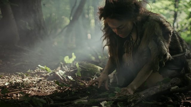 Prehistoric Cave Woman Hunter-Gatherer Searches for Nuts and Berries in the Forest. Primitive Neanderthal Woman Finding Food in the Sunny Forest
