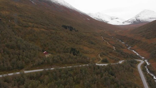 Aerial shot of cars driving on a curvy roads leading up the mountain in Eresfjord, Norway