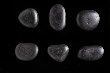 Black stones set on black background close up