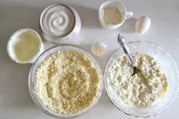 Cooked ingredients for curd casserole. Stand in bowls on the table. View from above. Cookery
