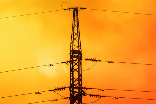 Silhouette of High voltage pylon on the orange sunset