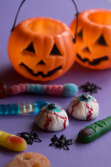 Fototapeta premium halloween candies with orange pumpkin in the background