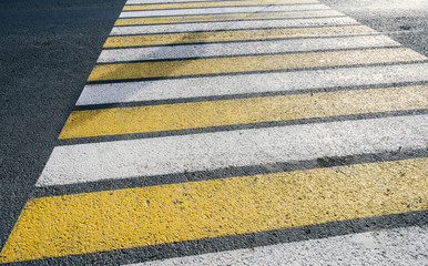 Detail of a yellow crosswalk on the road.