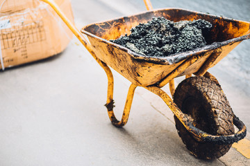 Yellow car with asphalt on a working construction site during the construction of the road