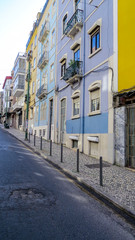 Fototapeta premium Typical street with coloured buildings with tiles (azuleios) wall of Lisbon, Portugal