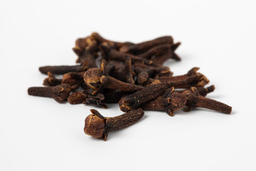 Dried cloves spices heap close up on white background