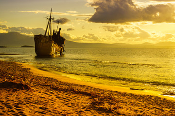 Rusty broken shipwreck on sea shore