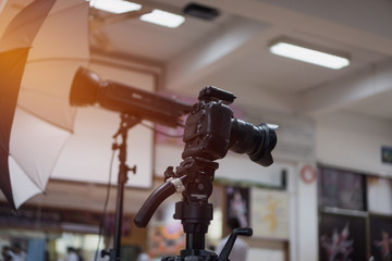 Photo camera digital dslr in studio with wireless sending on tripod for recording taking photograph in production house or convention hall in live event, media meeting  broadcast equipment.
