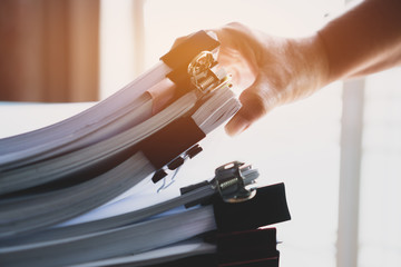 Businessman hands working in stacks documents of paper files, searching information on desk office,...