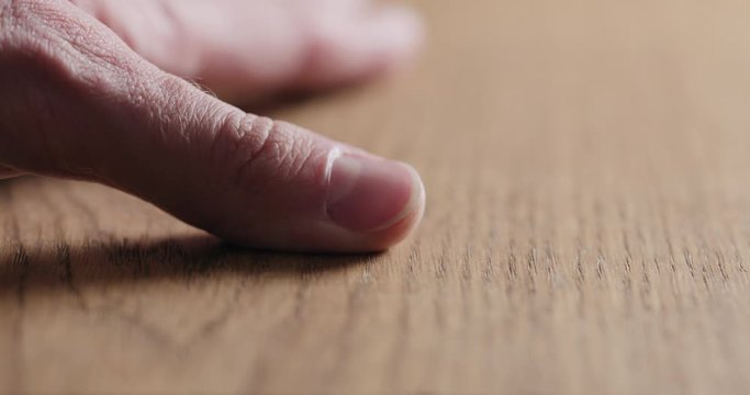 Slow motion man hand touch oil finished oak wood surface