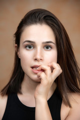 Young girl with nervous face expression biting fingernails portrait