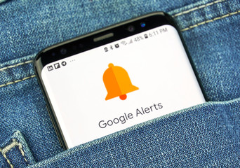 bonne veille concurrentielle Google Alerts on a phone screen in a pocket