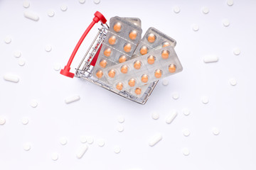 shopping cart with pills, medicines and bottles of medicines on white background. pharmacy medicines.
