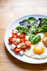 Breakfast - fried egg, toasts and vegetable salad