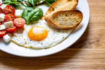 Breakfast - fried egg, toasts and vegetable salad