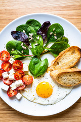 Breakfast - fried egg, toasts and vegetable salad