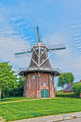 Typical Dutch windmill in a village in Groningen, The Netherlands, Europe.