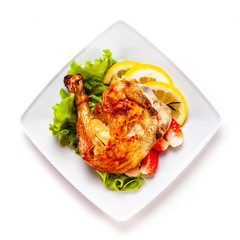 Grilled chicken leg with vegetables on white background