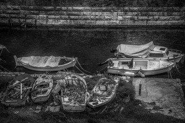 Black and white effect of boats moored next to destroyed old boats, Corfu, Greece