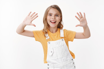 Cheerful cute funny blond girl child having fun, playing raising palms, show clean hands smiling...