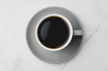 Grey cup with black coffee on on white background. Top view. Coffee break.