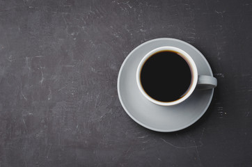 Grey cup with black coffee on on dark background. Top view and copy space. Coffee break.
